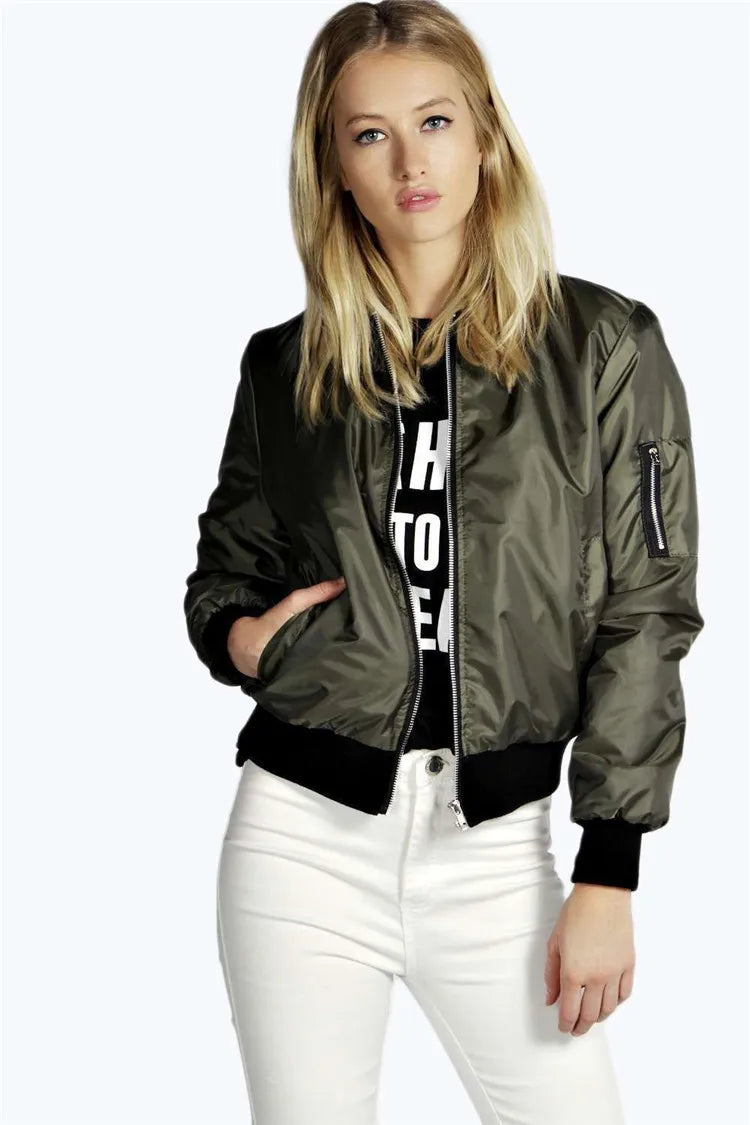 Woman wearing a olive green bomber jacket with black accents on a white background